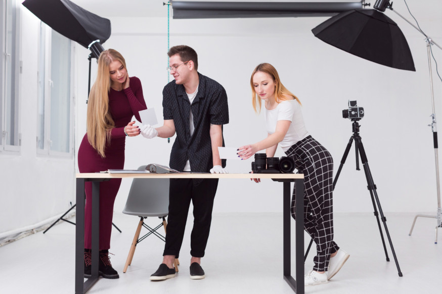 Afbeelding: Een creatief team van professionals en fotografen dat samenwerkt en resultaten bespreekt in een lichte fotostudio