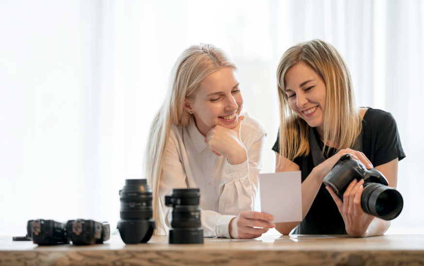 Afbeelding: Twee professionele fotografen bespreken samen een resultaat tijdens een coachingstraject voor hun fotografiebedrijf