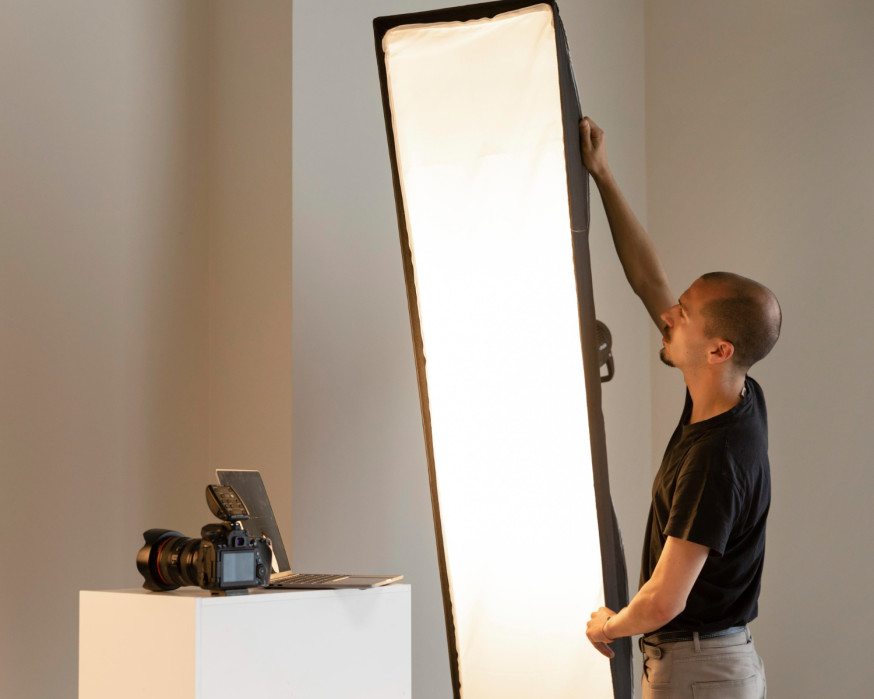 Afbeelding: Fotograaf stelt een grote lichtvormer in om schaduwen en lichtinval te controleren