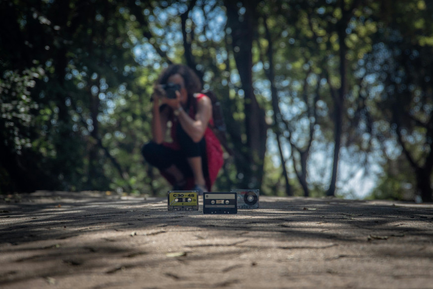 Afbeelding: fotograaf neemt een laag standpunt in om vintage cassettebandjes op de grond te fotograferen